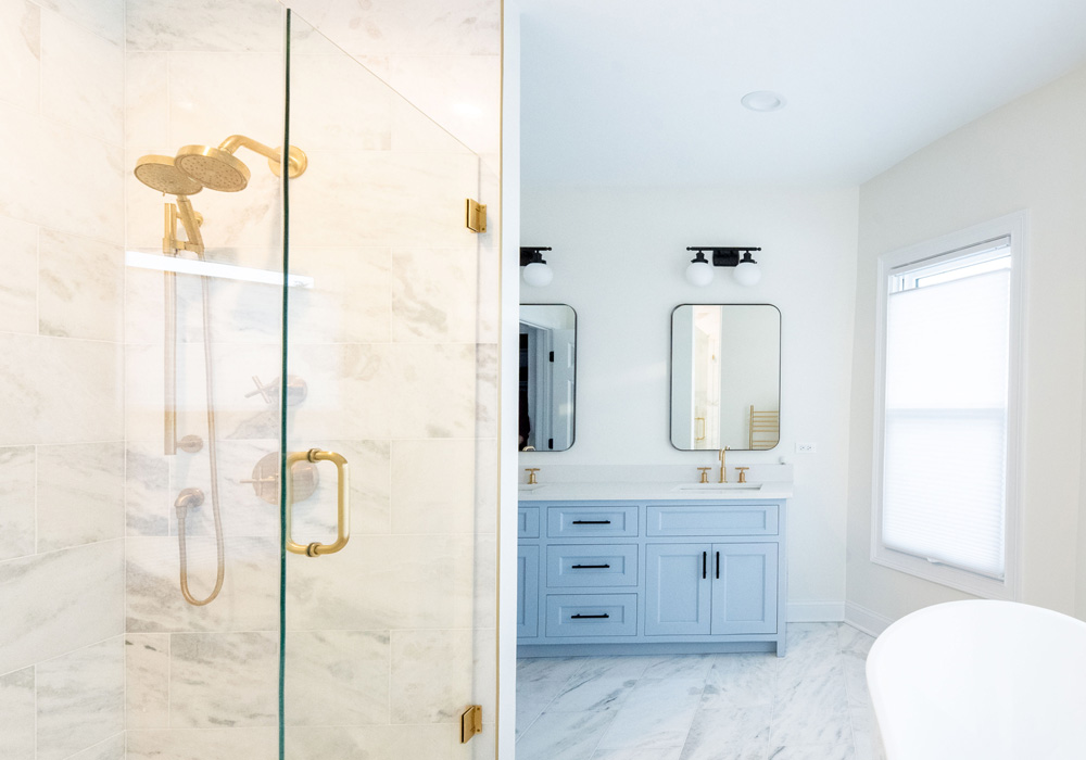 Newly remodeled luxury bathroom with gold fixtures and white stone.